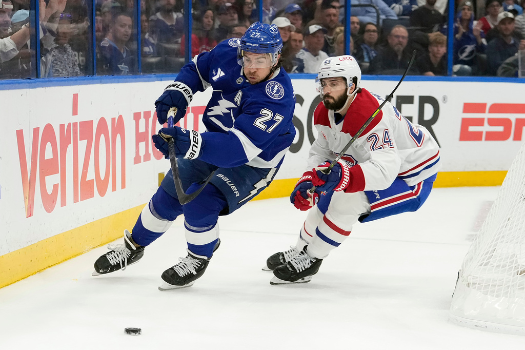 Tampa Bay Lightning defenseman Ryan McDonagh (27) beats Montréal Canadiens center Phillip Danault (24) to a loose puck during the first period in Game 5 of an NHL hockey Stanley Cup first-round playoff series, Wednesday, April 29, 2026, in Tampa, Fla. (AP Photo/Chris O'Meara)