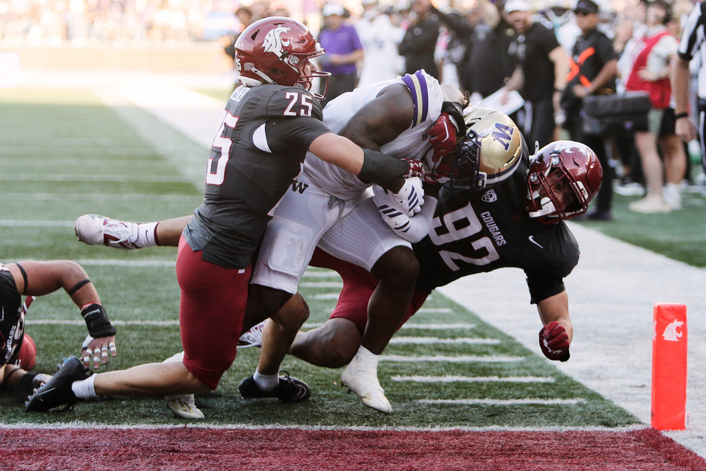 Washington running back Jonah Coleman, center, runs for a touchdown while pressured by Washington State safety Cale Reeder (25) and defensive tackle Darrion Dalton (92) during the first half of an NCAA college football game, Saturday, Sept. 20, 2025, in Pullman, Wash. (AP Photo/Young Kwak)