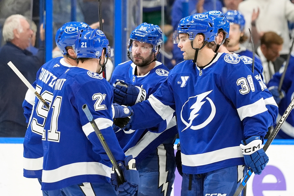 Tampa Bay Lightning right wing Nikita Kucherov (86, center) celebrates his goal against the Vancouver Canucks with teammates, including left wing Brandon Hagel (38) and center Brayden Point (21) during the second period of an NHL hockey game Saturday, Oct. 17, 2026, in Tampa, Fla. (AP Photo/Chris O'Meara)