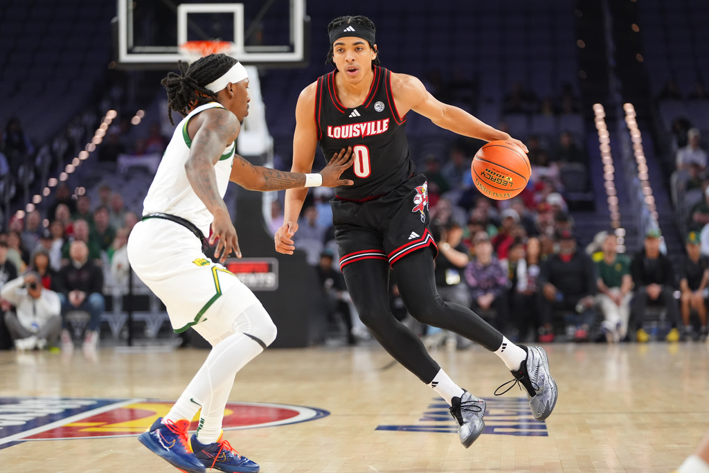 Louisville guard Mikel Brown Jr. (0) dribbles against Baylor guard Obi Agbim, left, during the first half of an NCAA college basketball game Saturday, Feb. 14, 2026, in Fort Worth, Texas. (AP Photo/LM Otero)