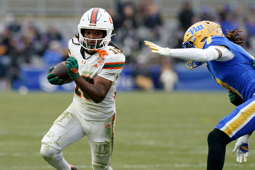 Miami wide receiver Malachi Toney (10) carries as he's defended by Pittsburgh defensive back Tamon Lynum (8) during the second half of an NCAA college football game, Saturday, Nov. 29, 2025, in Pittsburgh. (AP Photo/Matt Freed)