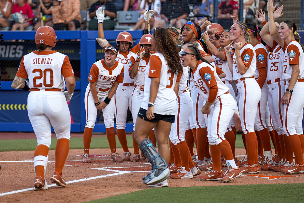 The Texas Longhorns celebrate a home run by infielder Katie Stewart (20) during Game 1 of the NCAA Women's College World Series softball championship series against Texas Tech on Wednesday, June 3, 2026 in Oklahoma City, Oklahoma.(Aaron E. Martinez/Austin American-Statesman via AP)