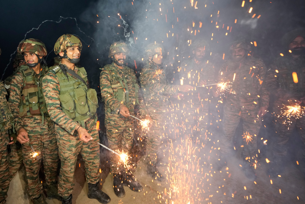 Indian army soldiers light firecrackers to celebrate Diwali, near the Line of Control that divides Kashmir region between India and Pakistan, in Akhnoor sector, Jammu and Kashmir, India, Thursday, Oct. 16, 2025. (AP Photo/Channi Anand)