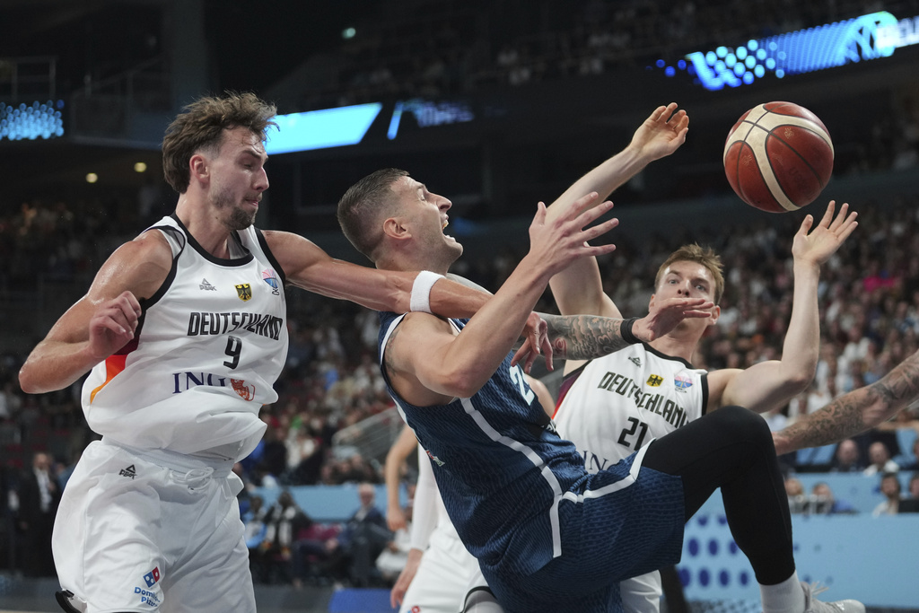 Germany's Franz Wagner, left, Slovenia's Alen Omic, centre, Germany's Justus Hollatz in action during the Eurobasket, European Basketball Championship quarter final match between Germany and Slovenia at the Riga Arena in Riga, Latvia, Wednesday, Sept. 10, 2025. (AP Photo/Sergei Grits)