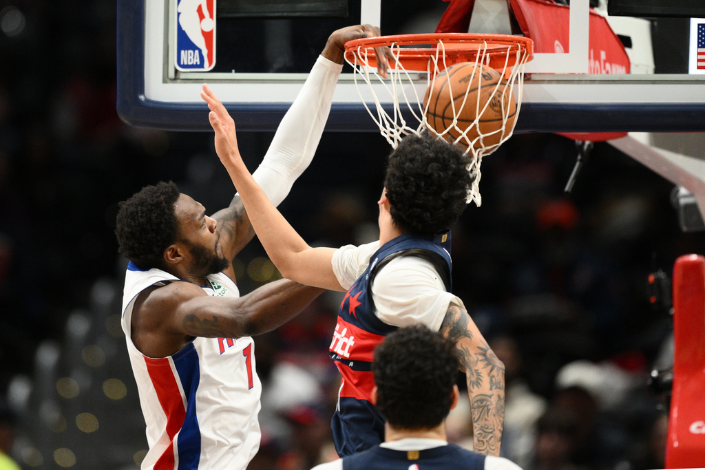Detroit Pistons forward Paul Reed, left, dunks over Washington Wizards guard Will Riley, right, during the first half of an NBA basketball game, Thursday, March 19, 2026, in Washington. (AP Photo/Nick Wass)