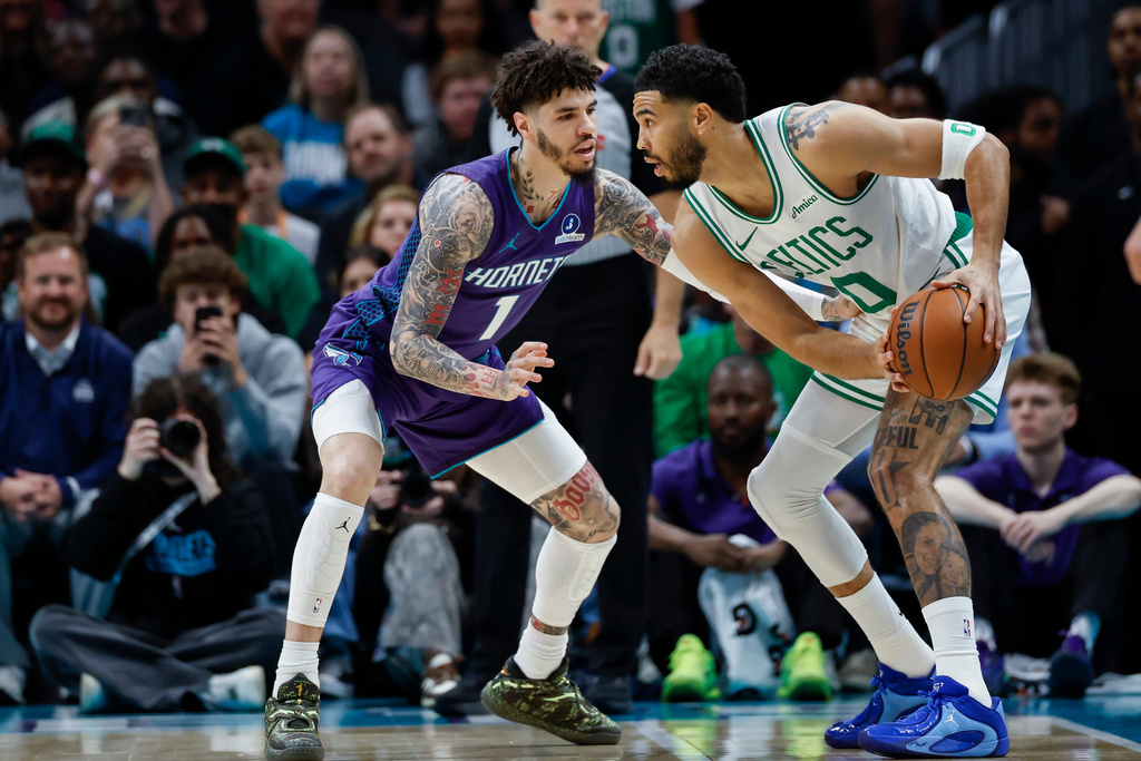 Boston Celtics forward Jayson Tatum, right, looks to drive against Charlotte Hornets guard LaMelo Ball (1) during the first half of an NBA basketball game in Charlotte, N.C., Sunday, March 29, 2026. (AP Photo/Nell Redmond)