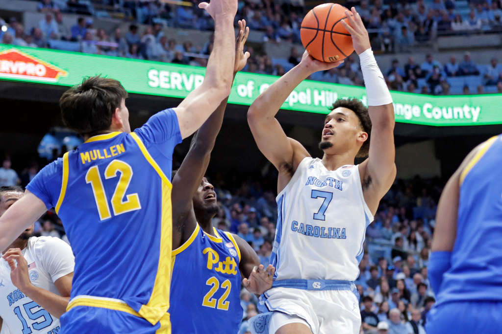 North Carolina guard Seth Trimble (7) shoots over Pittsburgh center Kieran Mullen (12) and guard Barry Dunning Jr. (22) during the first half of an NCAA college basketball game Saturday, Feb. 14, 2026, in Chapel Hill, N.C. (AP Photo/Chris Seward)