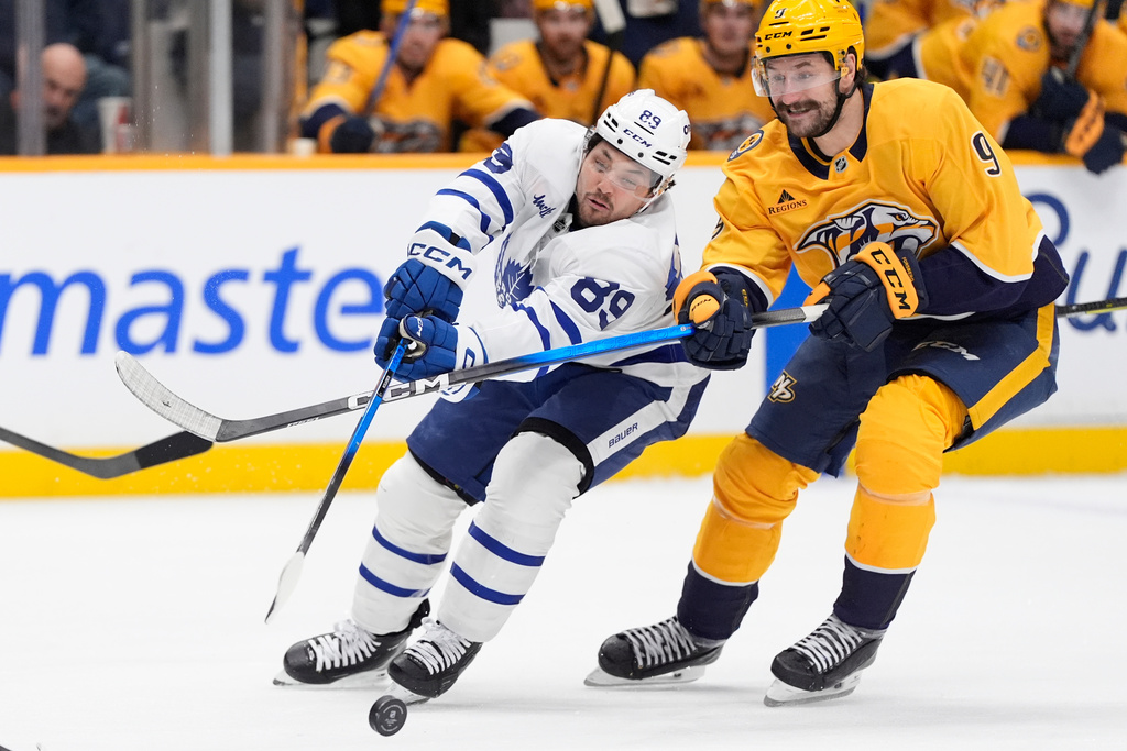Toronto Maple Leafs left wing Nicholas Robertson (89) and Nashville Predators left wing Filip Forsberg (9) chase a loose puck during the third period of an NHL hockey game Saturday, Dec. 20, 2025, in Nashville, Tenn. (AP Photo/George Walker IV)