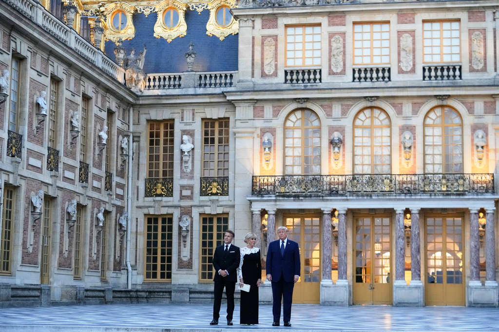 France's President Emmanuel Macron, left, his wife Brigitte, left, and U.S. President Donald Trump pose before a private dinner to celebrate the USA's 250th birthday, at the Palace of Versailles, outside Paris, Wednesday, June 17, 2026. (AP Photo/Michel Euler)
