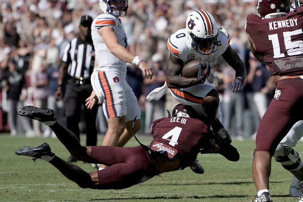 Auburn running back Damari Alston (0) is stopped in the backfield by Texas A&M cornerback Will Lee III (4) during the first half of an NCAA college football game Saturday, Sept. 27, 2025, in College Station, Texas. (AP Photo/Sam Craft)