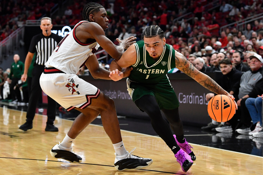 Eastern Michigan guard Mak Manciel drives past Louisville guard Adrian Wooley during the first half of an NCAA college basketball game in Louisville, Ky., Monday, Nov. 24, 2025. (AP Photo/Timothy D. Easley)