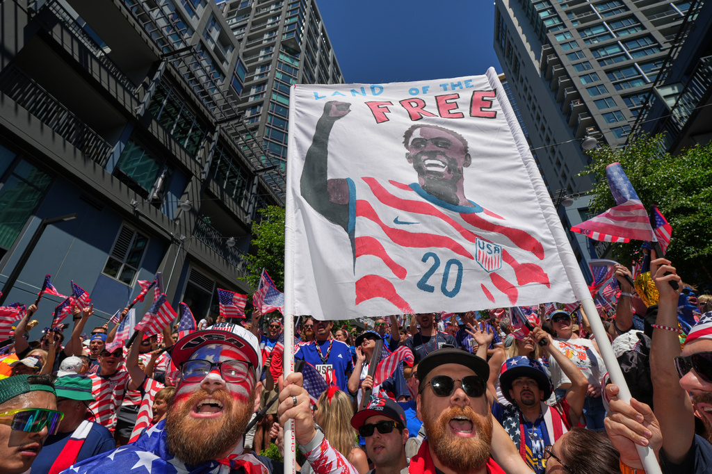 United States soccer fans, one holding a sign for United States' Folarin Balogun (20) react during the World Cup round of 16 soccer match between the United States and Belgium in Seattle, Monday, July 6, 2026. (AP Photo/Eric Hiller)