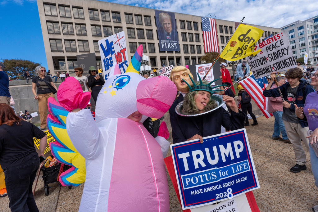 Demonstrators wear inflatable costumes and carry signs during a No Kings protest, Saturday, Oct. 18, 2025, in Washington. (AP Photo/Alex Brandon)