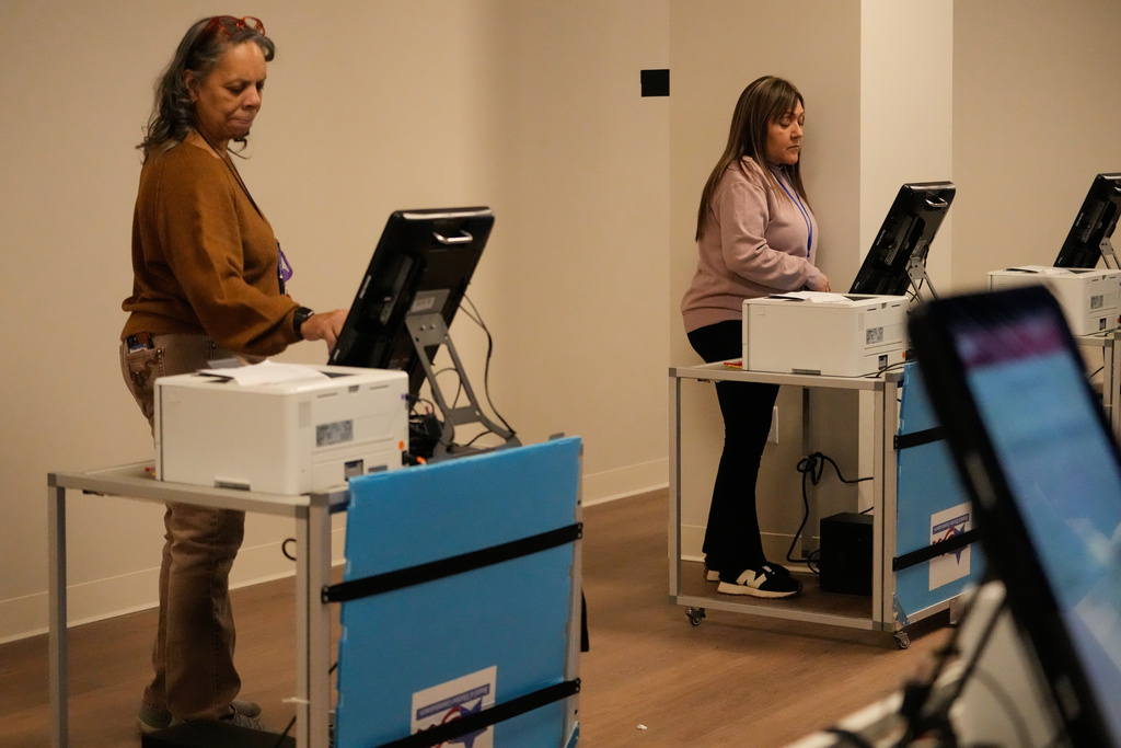Election Voting Official Debra Mikell, left, and Patricia Ocon check touchscreen voting machine at New Chicago Voter Supersite in Chicago, Tuesday, Feb. 10, 2026. (AP Photo/Nam Y. Huh)