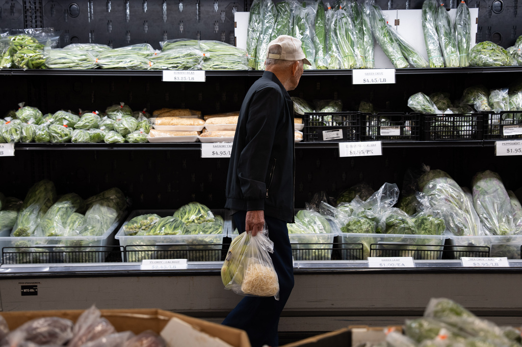 A customer walks by produce at a grocery store in Portland, Ore., Wednesday, April 8, 2026. (AP Photo/Jenny Kane)