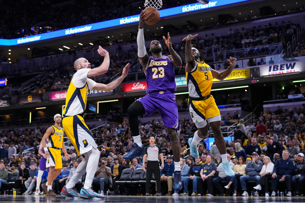 Los Angeles Lakers forward LeBron James (23) shoots between Indiana Pacers forward Jarace Walker (5) and center Jay Huff (32) during the second half of an NBA basketball game in Indianapolis, Wednesday, March 25, 2026. (AP Photo/Michael Conroy)