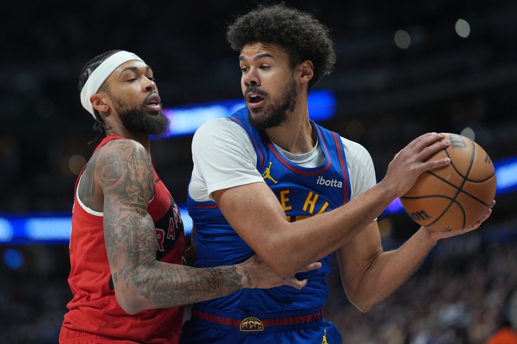 Toronto Raptors forward Brandon Ingram, left, stops Denver Nuggets forward Cameron Johnson as he tries to drive the baseline to the net in the first half of an NBA basketball game Friday, March 20, 2026, in Denver. (AP Photo/David Zalubowski)