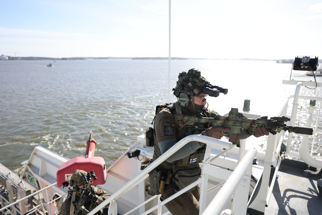 A member of the Finnish Border Guard takes part in an exercise, during the JEF leaders' visit on the Finnish Border Guard offshore patrol vessel Turva, prior to the Joint Expeditionary Force JEF Leaders' Summit in Helsinki, Finland, Thursday March 26, 2026. (Adrian Dennis, Pool Photo via AP)
