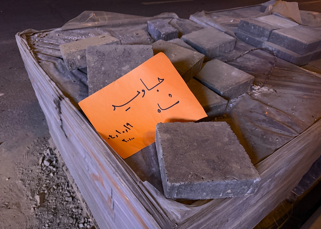In this photo obtained by The Associated Press, a placard is placed on bricks that reads in Farsi, "Long live the Shah," referring to the Pahlavi dynasty that was toppled in the 1979 Islamic Revolution, during an anti-government protest in Tehran, Iran, Friday, Jan. 9, 2026. (UGC via AP)