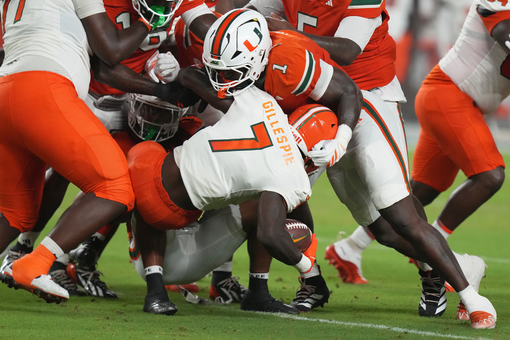 Miami linebacker Mohamed Toure (1) defends Florida A&M running back Chase Gillespie (7) during the first half of an NCAA college football game, Thursday, Sept. 10, 2026, in Miami Gardens, Fla. (AP Photo/Lynne Sladky)