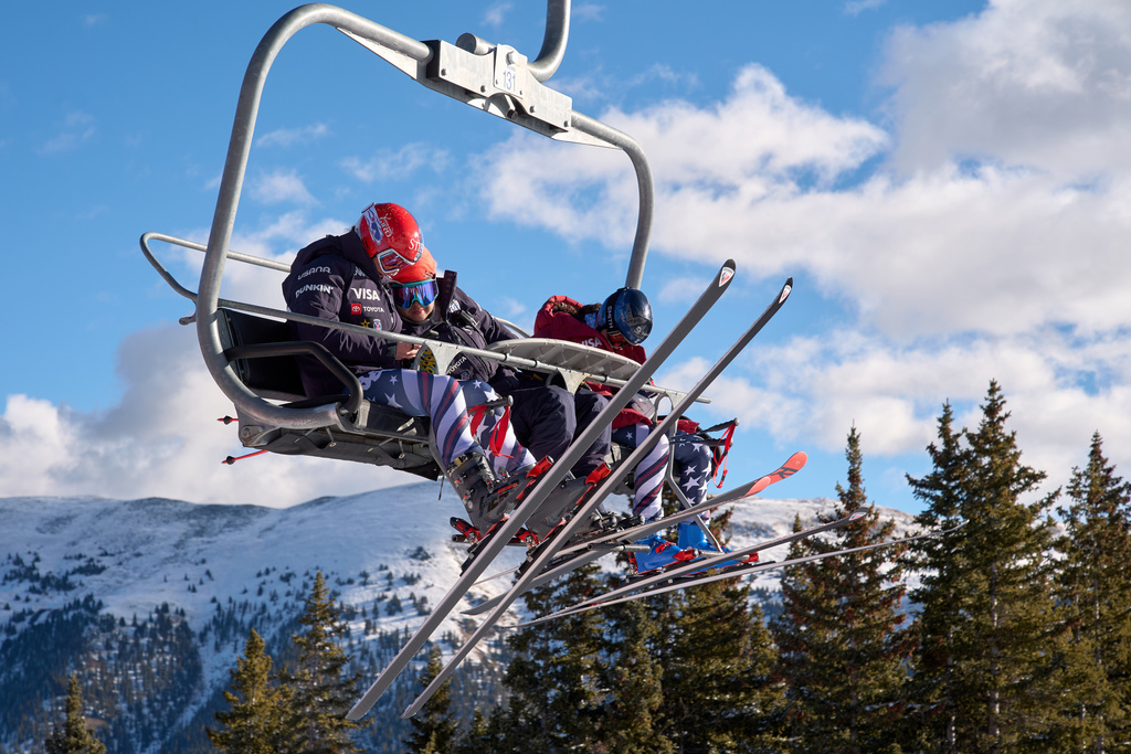 Skier Lauren Macuga, left, looks at her cell phone with ski technician Rok Javor and skier Jackie Wiles as they take the chairlift up the hill for U.S. Women's Ski Team practice at Copper Mountain, Colo., Nov. 19, 2025. (AP Photo/Jacquelyn Martin)