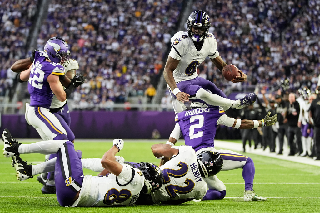 Baltimore Ravens quarterback Lamar Jackson (8) hurdles over Minnesota Vikings cornerback Isaiah Rodgers (2) near the goal line in the second half of an NFL football game, Sunday, Nov. 9, 2025, in Minneapolis. (AP Photo/Abbie Parr)