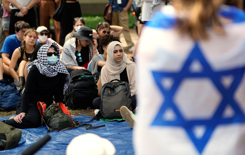 FILE - A student wrapped in an Israeli flag listens to Pro-Palestinian protesters gathered on campus at the University of Texas at Austin, April 30, 2024, in Austin, Texas. (AP Photo/Eric Gay, File)