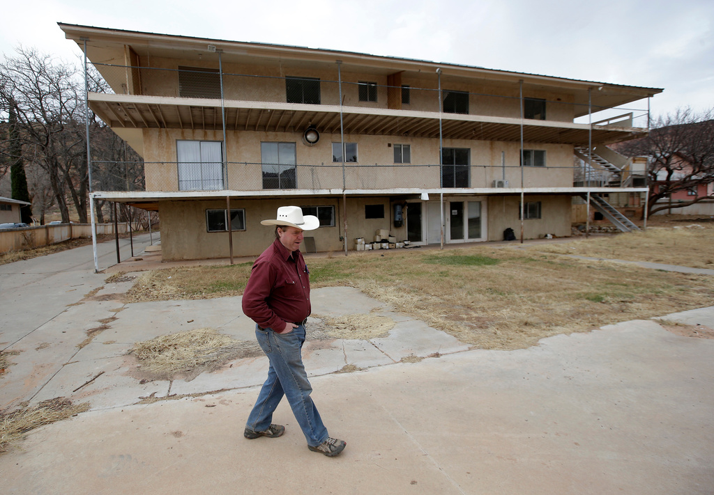 FILE - Isaac Wyler, a former member of The Fundamentalist Church of Jesus Christ of Latter-Day Saints (FLDS), stands in front of an evicted polygamous property, in Hildale, Utah, on Dec. 16, 2014. (AP Photo/Rick Bowmer, File)