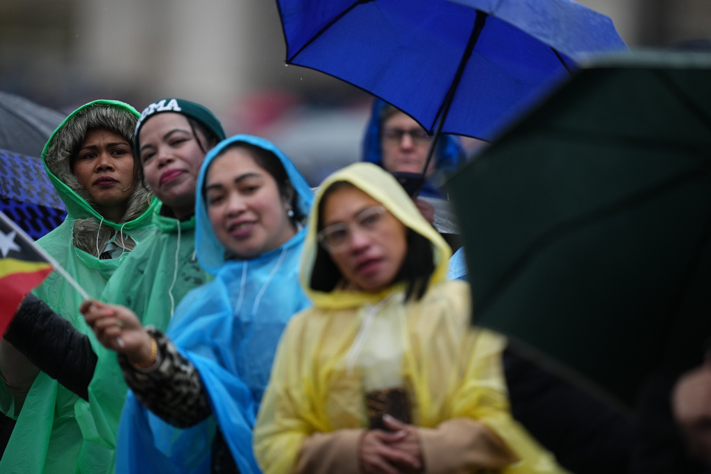 People wait for Pope Leo XIV to deliver the Angelus noon prayer from the central loggia of St. Peter's Basilica at the Vatican, Tuesday, Jan. 6, 2026. (AP Photo/Alessandra Tarantino)