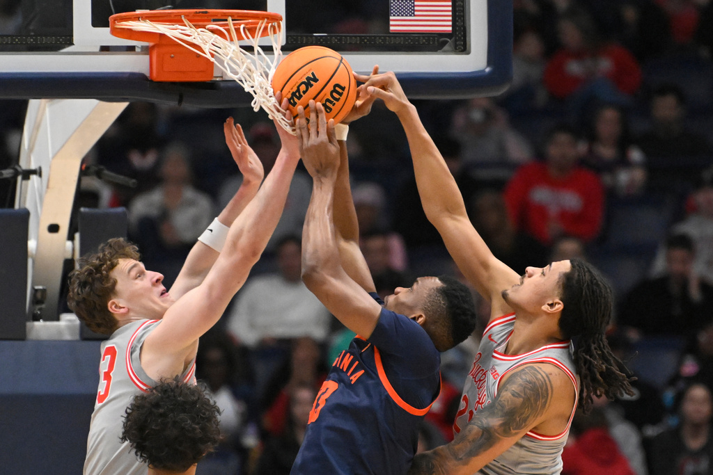 Ohio State forward Devin Royal, right, fouls Virginia center Ugonna Onyenso as center Christoph Tilly, left, defends during the first half of an NCAA college basketball game Saturday, Feb. 14, 2026, in Nashville, Tenn. (AP Photo/John Amis)