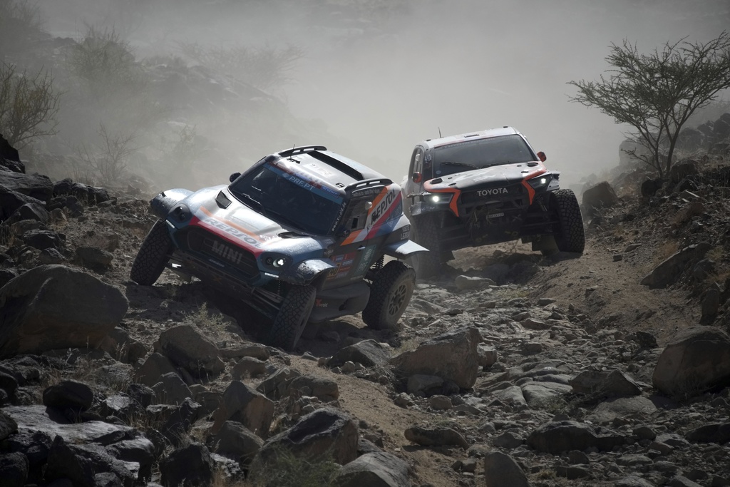 Driver Joao Ferreira and co-driver Filipe Palmeiro, in the car at left, compete during stage one of the Dakar Rally with start and finish in Bisha, Saudi Arabia, Saturday, Jan. 4, 2025. (AP Photo/Christophe Ena)