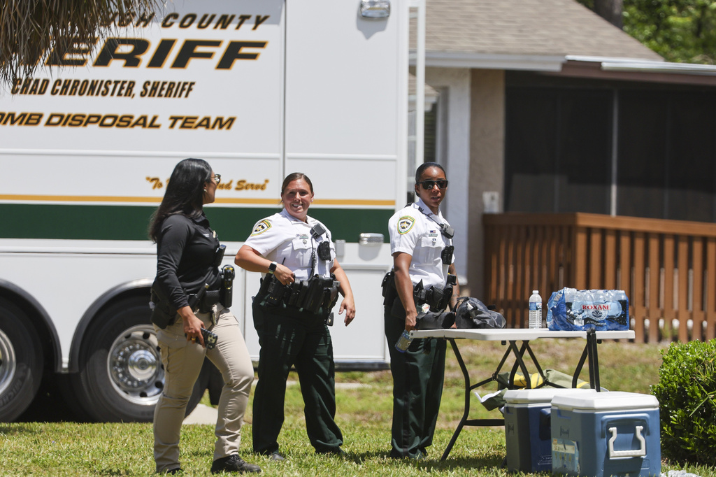 Deputies with the Hillsborough County Sheriff's Office join an investigation inside the Lake Forest subdivision of Tampa, Fla., on Friday, April 24, 2026, where authorities said a man was taken into custody after barricading himself inside a home, in connection to the search for two missing University of South Florida graduate students. (Douglas R. Clifford/Tampa Bay Times via AP)
