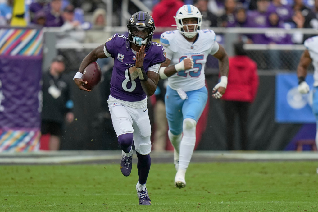 Baltimore Ravens quarterback Lamar Jackson (8) runs the ball past Tennessee Titans defensive end Keldric Faulk (15) during the first half of an NFL football game in Baltimore, Sunday, Oct. 4, 2026. (AP Photo/Stephanie Scarbrough)