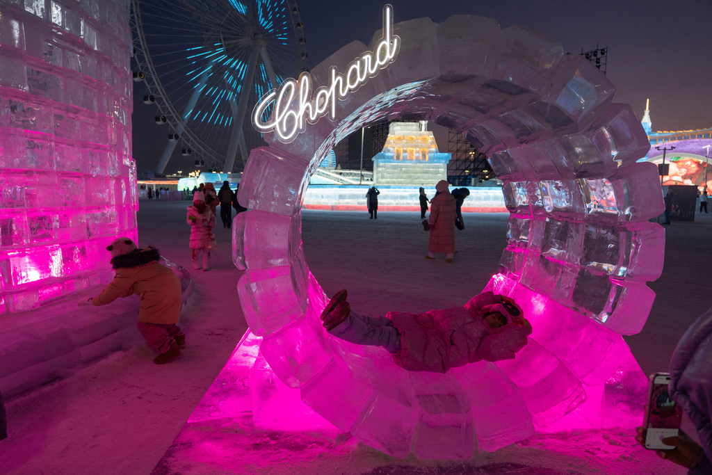 A child lies in an ice sculpture during the annual Ice and Snow Festival held in Harbin in China's Heilongjiang province on Saturday, Jan. 3, 2026. (AP Photo/Ng Han Guan)