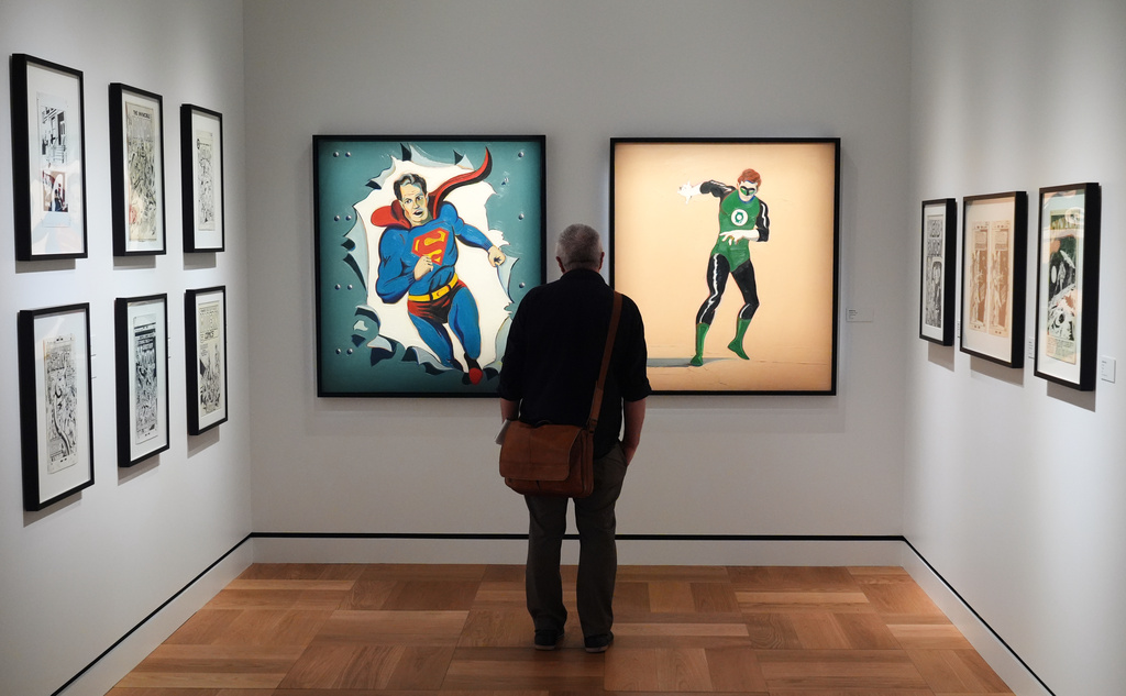 A visitor looks at Mel Ramos' oil paintings "Man of Steel," left, and "The Green Lantern" during a preview of the Lucas Museum of Narrative Art on Monday, Aug. 31, 2026, in Los Angeles. (AP Photo/Chris Pizzello)
