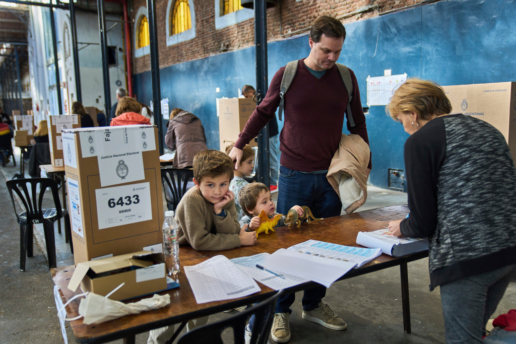 Patricio Irarrazabal arrives to vote with his sons during legislative midterm elections in Buenos Aires, Argentina, Sunday, Oct. 26, 2025. (AP Photo/Rodrigo Abd)