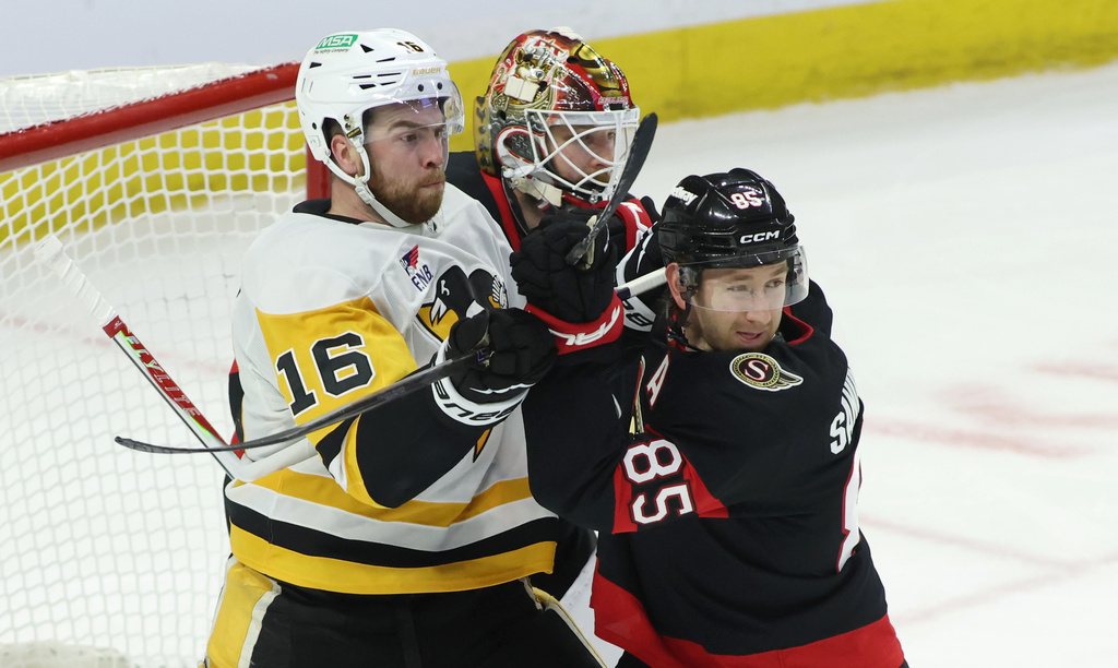 Pittsburgh Penguins' Justin Brazeau (16) and Ottawa Senators' Jake Sanderson (85) battle in front of Senators goaltender Linus Ullmark, center, during second-period NHL hockey game action in Ottawa, Ontario, Thursday, Dec. 18, 2025. (Patrick Doyle/The Canadian Press via AP)
