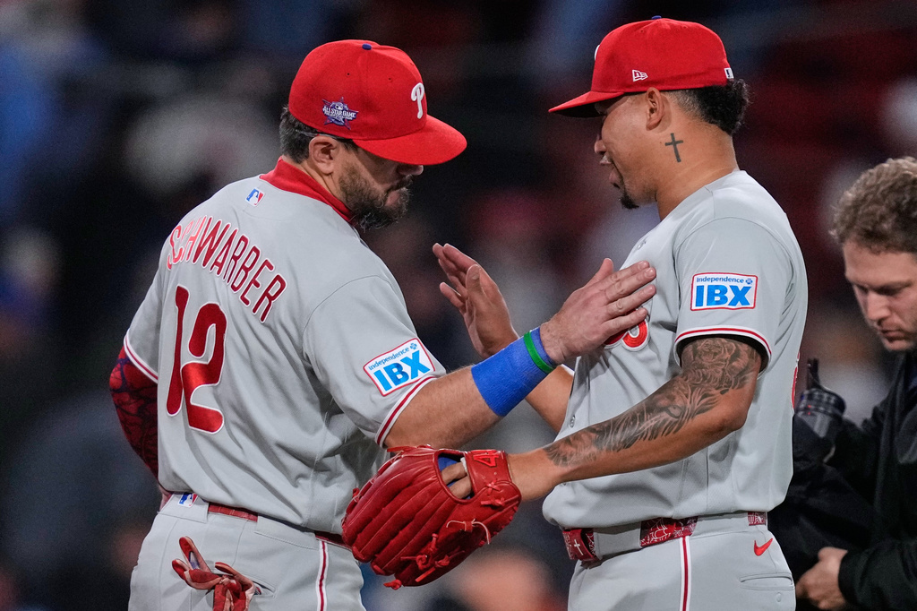 Philadelphia Phillies left fielder Kyle Schwarber (12) celebrates with pitcher Jhoan Duran after defeating the Boston Red Sox following a baseball game, Thursday, May 14, 2026, in Boston. (AP Photo/Charles Krupa)