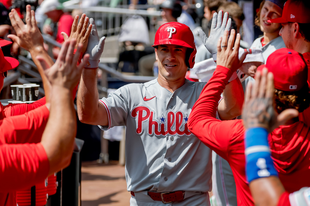 Philadelphia Phillies' J.T. Realmuto is greeted in the dugout after hitting a two-run home run against the Atlanta Braves during the second inning of a baseball game, Sunday, Sept. 13, 2026, in Atlanta. (AP Photo/Erik S. Lesser)