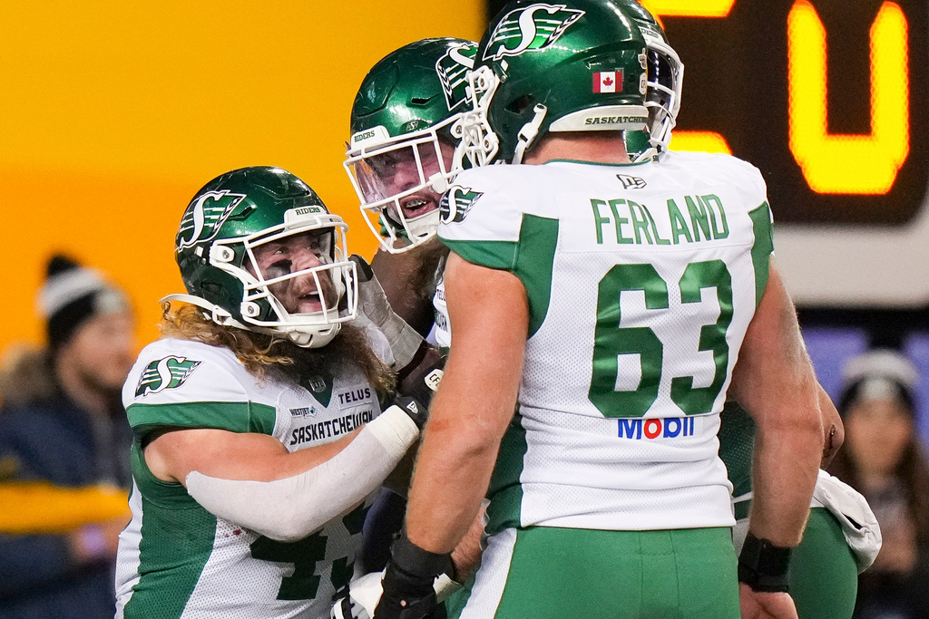 Saskatchewan Roughriders' A.J. Ouellette (45), left, celebrates his touchdown with teammates while taking on the Montreal Alouettes during first half CFL football action in the Grey Cup in Winnipeg, Manitoba, Sunday, Nov. 16, 2025. (Darryl Dyck/The Canadian Press via AP)