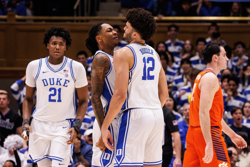 Duke's Cameron Boozer (12) and Isaiah Evans, second from left, and Patrick Ngongba II (21) celebrate after a play ahead of Clemson's Nick Davidson, right, during the second half of an NCAA college basketball game in Durham, N.C., Saturday, Feb. 14, 2026. (AP Photo/Ben McKeown)