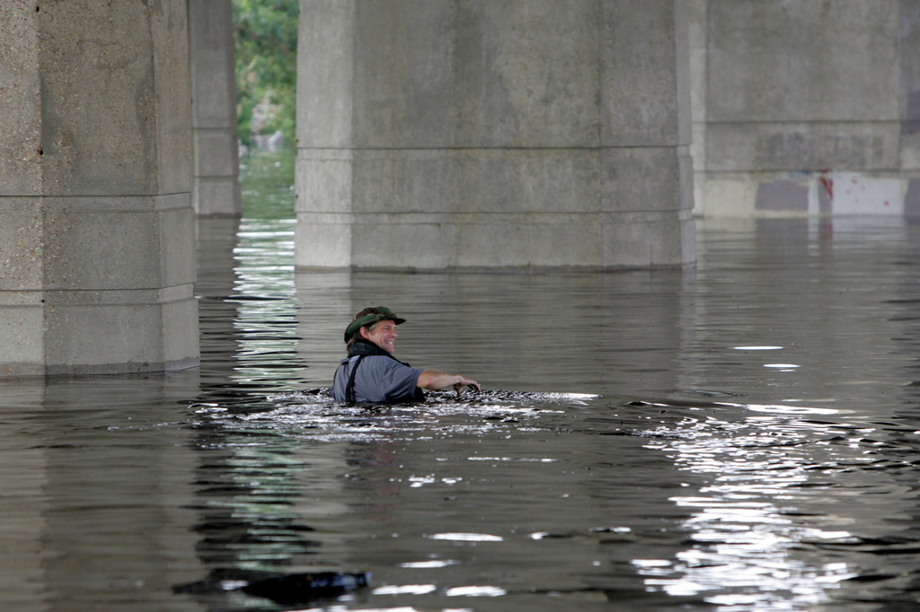FILE - Times-Picayune staff photographer Alex Brandon swims away from the paper's building during the aftermath of Hurricane Katrina after dropping off a memory card in New Orleans, Aug. 30, 2005. (AP Photo/Bill Haber, File)