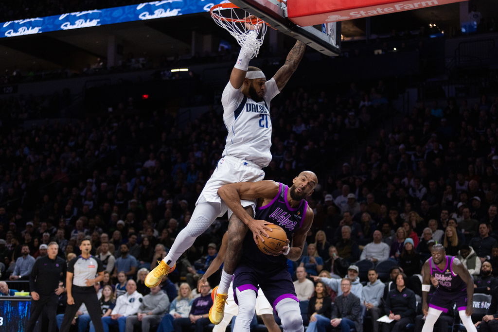 Dallas Mavericks' Daniel Gafford (21) goes against Rudy Gobert (27) at the basket during the first half of an NBA basketball game Friday Feb. 20, 2026, in Minneapolis. (AP Photo/Lily Dozier)
