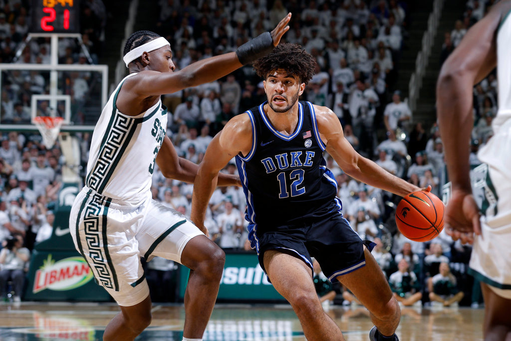 Duke forward Cameron Boozer (12), right, drives against Michigan State forward Cam Ward during the first half of an NCAA college basketball game, Saturday, Dec. 6, 2025, in East Lansing, Mich. (AP Photo/Al Goldis)