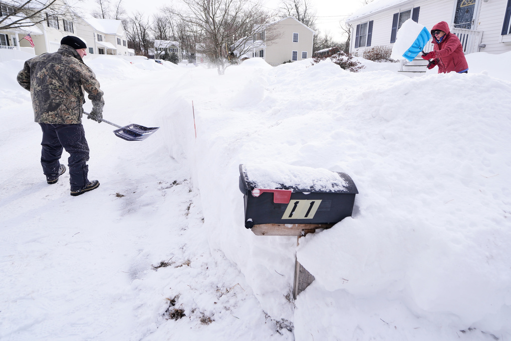 Todd Thibaud, left, and his wife Susan dig out their driveway and walkway following a winter storm that dumped more than a foot and a half of snow across the region, Tuesday, Jan. 27, 2026, in Haverhill, Mass. (AP Photo/Charles Krupa)