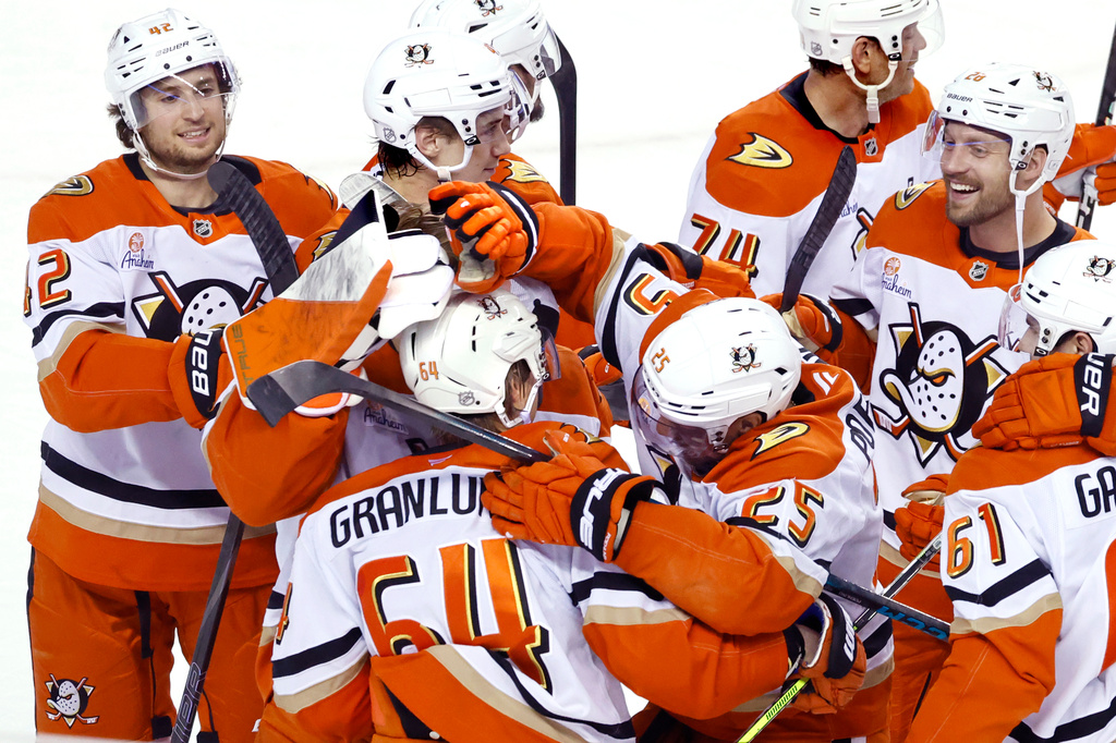 Anaheim Ducks' Mikael Granlund (64) is congratulated by teammates after scoring the game-winning goal against the Calgary Flames in overtime in an NHL hockey game in Calgary, Alberta, Thursday, March 26, 2026. (Larry MacDougal/The Canadian Press via AP)