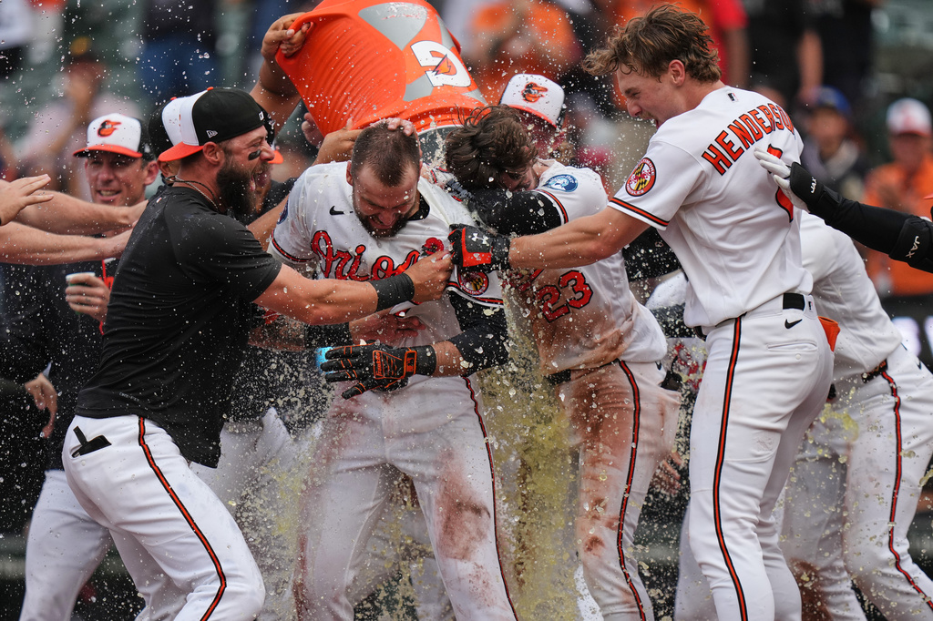 Baltimore Orioles' Colton Cowser, center, celebrates with teammates after hitting a walk off two-run home run during the 13th inning of a baseball game against the Tampa Bay Rays, Monday, May 25, 2026, in Baltimore. (AP Photo/Stephanie Scarbrough)