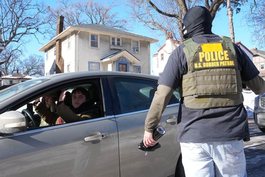 A federal agent approaches a vehicle on Thursday, Jan. 29, 2026, in Minneapolis. (AP Photo/Adam Gray)