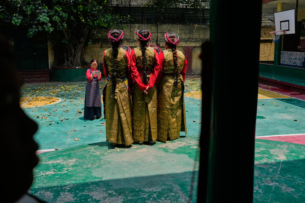 Exiled Tibetan women wearing traditional dress pose for photographs before their performance during celebrations marking the birthday of Tibetan spiritual leader the Dalai Lama at a Tibetan school in New Delhi, India, Monday, July 6, 2026. (AP Photo/Manish Swarup)