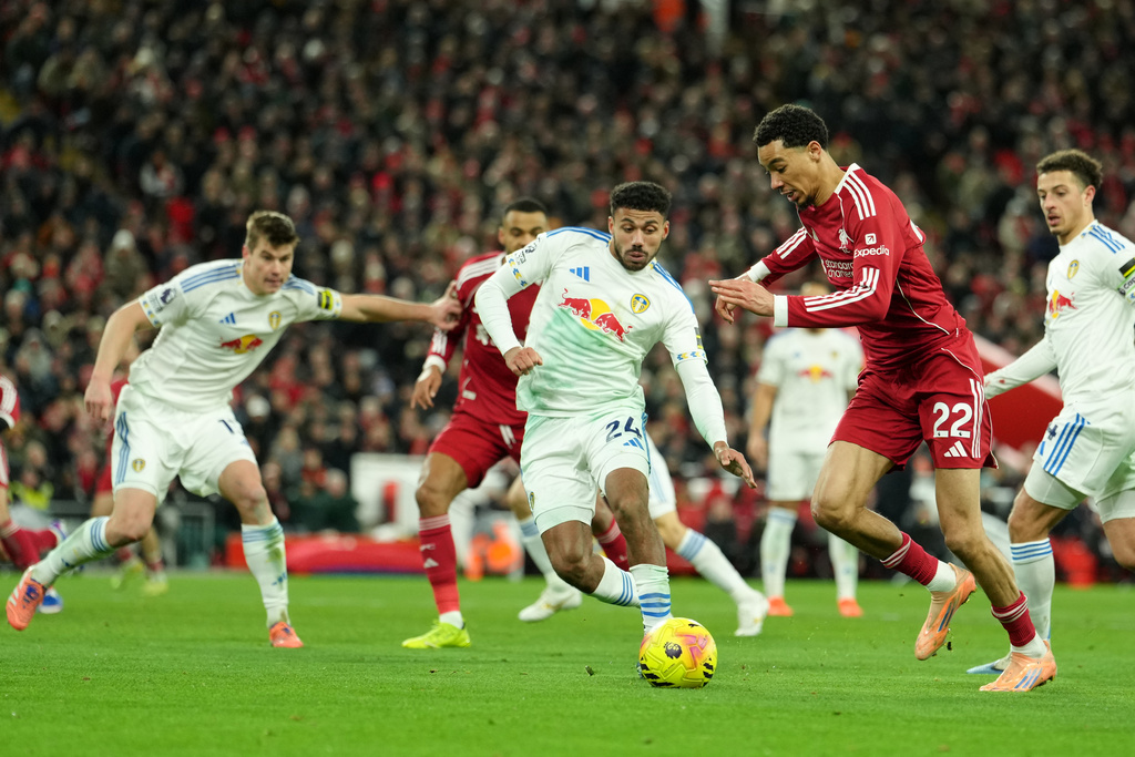 Liverpool's Hugo Ekitike, right, and Leeds' James Justin, center, challenge for the ball during the English Premier League soccer match between Liverpool and Leeds United in Liverpool, England, Thursday, Jan. 1, 2026. (AP Photo/Jon Super)